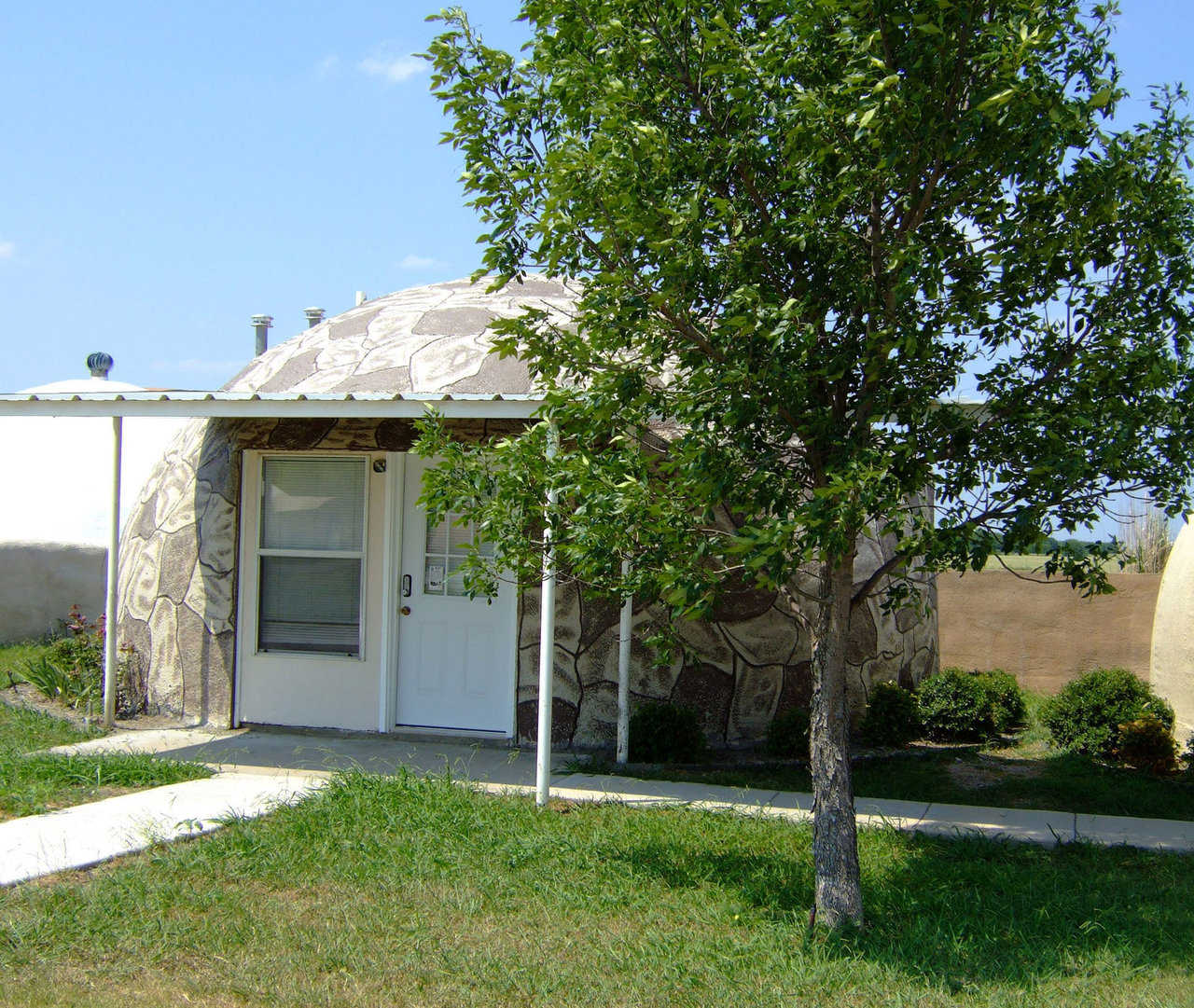 IO-24 — This IO-24 is located on the Monolithic Dome Institute’s property in Italy, Texas.  It is a 450 square foot rental unit.  The concrete coating on the outside of this dome was stained using  a siliconized concrete stain.