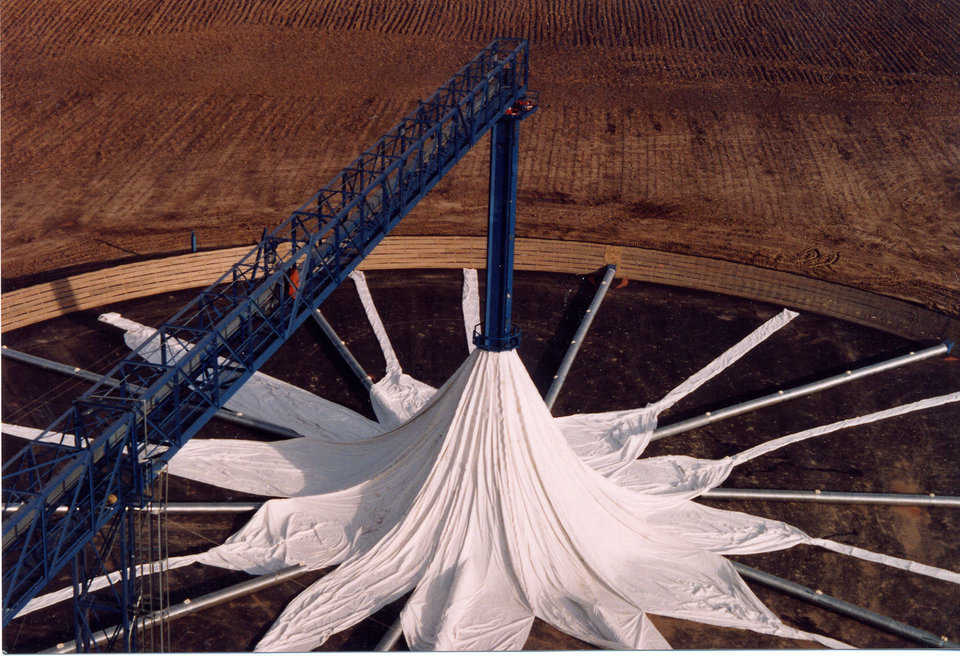 Partially assembled grain cover — Each of the gores (sections) is fastened to a lifting ring around the center tower. As the lifting ring rises, the gores attach to each other.
