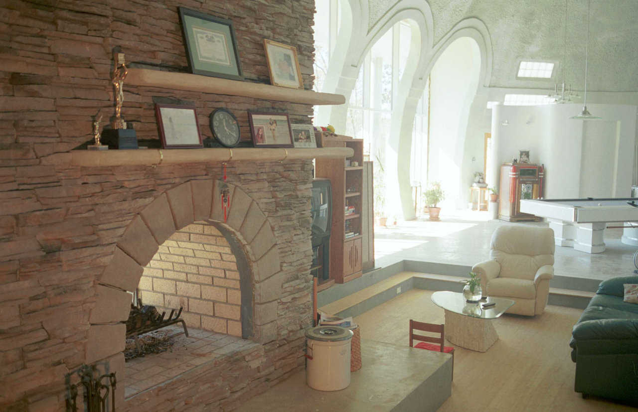 Window wall — Large, store-front windows open onto a gorgeous view. Window wall is 30’ wide and 16’ high. Arches are 8’ wide and 15’ high. Glass panels measure 5′ × 8′. Jim hand-formed the fireplace mantel using a stuccolike material.