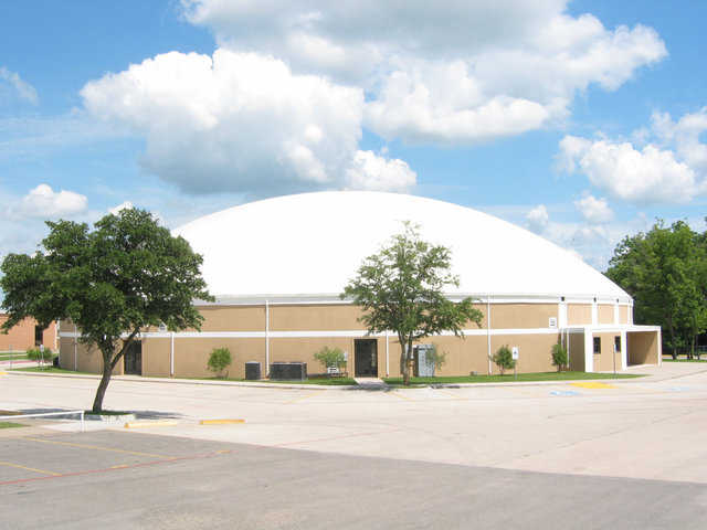 Gladiator Coliseum at Italy, Texas High School — This Monolithic Dome  has a diameter of 148 feet, two stories with seating for 1500, a gym with a walking track, an auditorium, classrooms for special activities, concession stands, ticket booths, locker rooms and bathrooms, and concrete parking areas. Its 2002 construction cost: $85 per square foot.