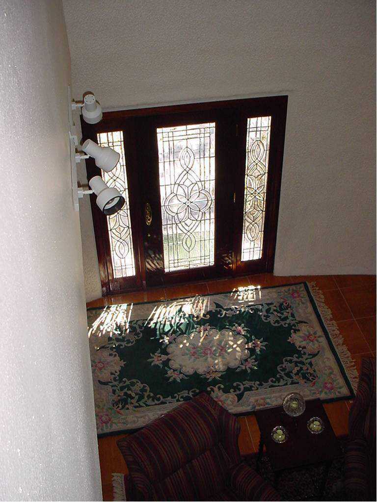 Entryway — A mahogany, leaded glass front door with matching side lights welcomes visitors.
