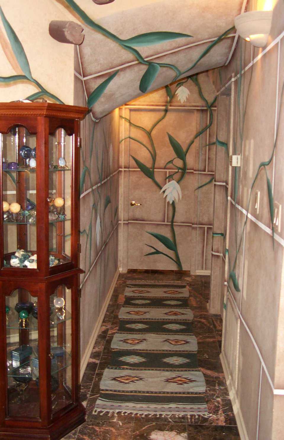 A Flowering Hallway — Large lotus flowers give the hallway a garden effect. Curio cabinet houses an impressive collection of gems and crystals.