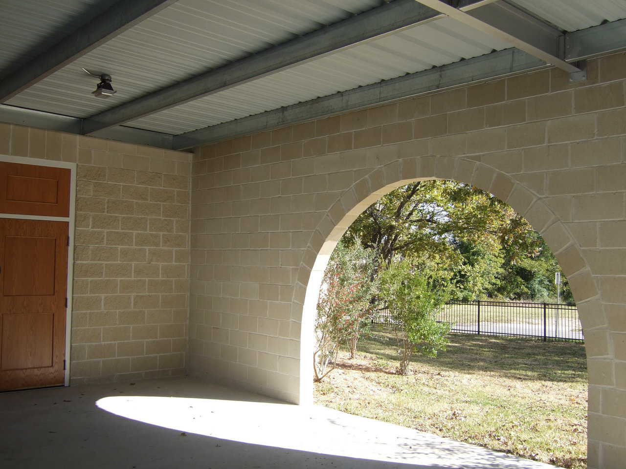 Arched openings — The connecting wall between the new dome-church and the old church has three arched entrances that open onto the covered patio/walkway.