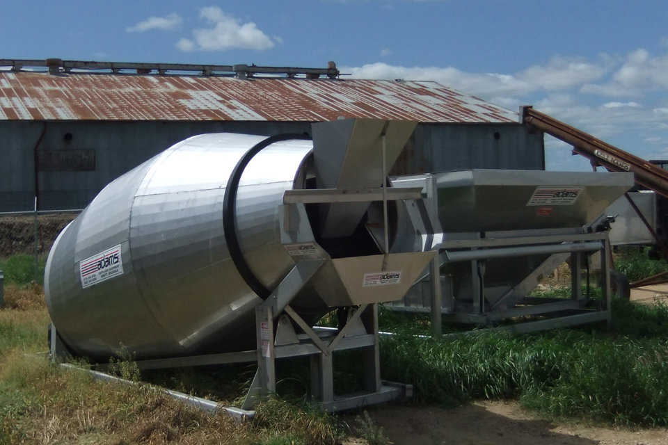 Blending equipment — The mixer barrel is similar to that of a concrete truck. Material from various bins is loaded into the weigh hopper (on the right), then added to the mixer barrel, mixed and loaded onto a truck.