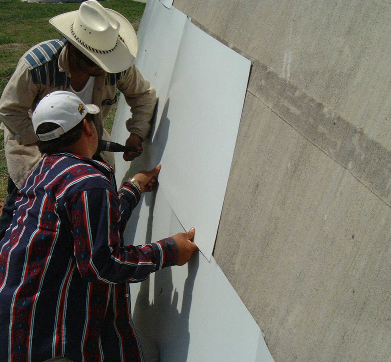 Round-and-round they go! — Workers encircle the dome with metal cladding.