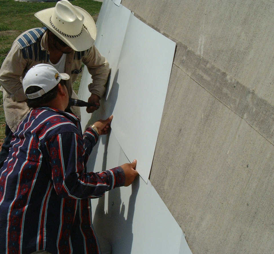 Round-and-round they go! — Workers encircle the dome with metal cladding.