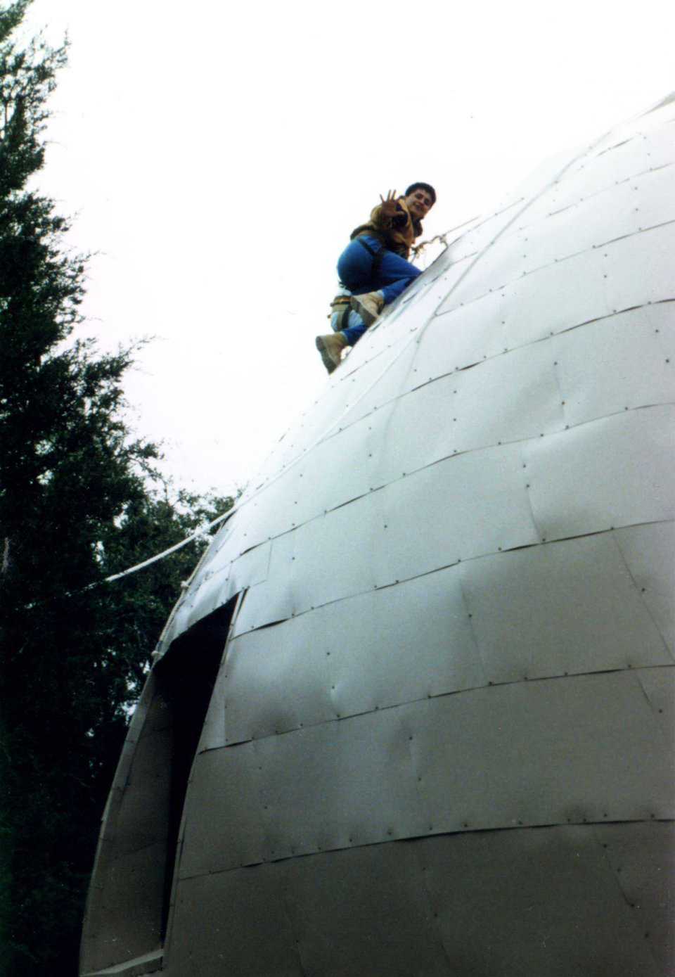 Going up! — Tethered worker installs metal cladding.