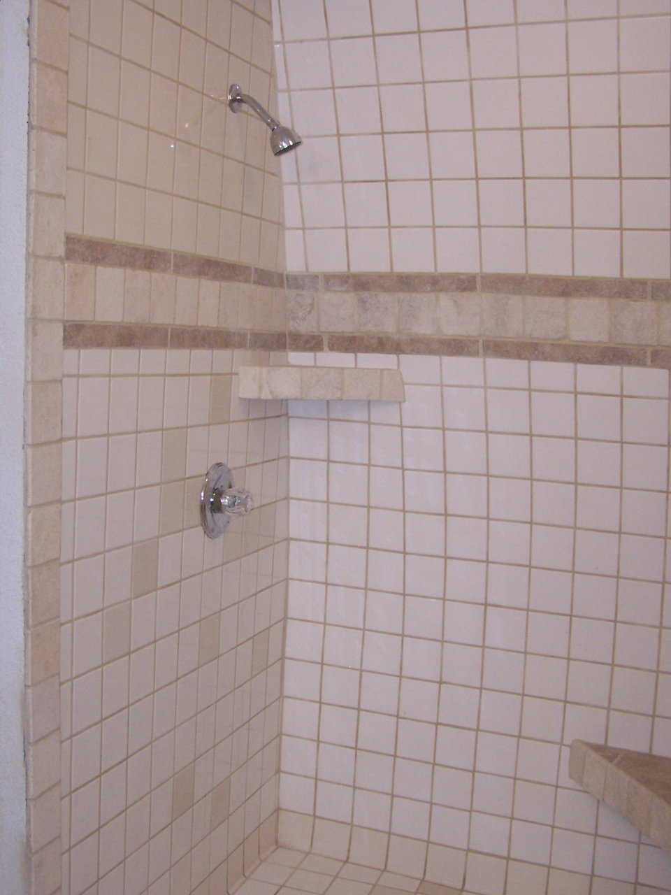 Shower — The tiled shower sports a convenient seat.