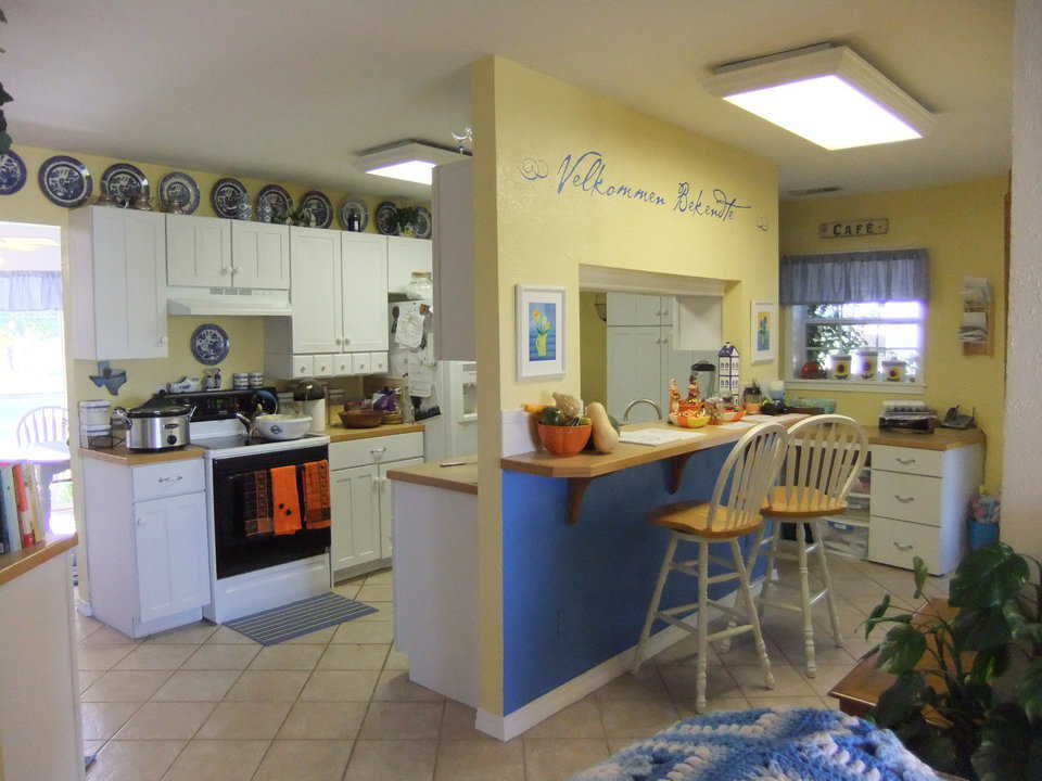 Kitchen and Breakfast Bar — Warmly painted walls and gaily curtained windows create a delightful cooking and eating area.