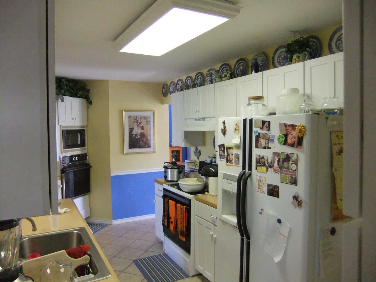 Plate Collection — A collection of blue plates enhances the open area above the kitchen cupboards.