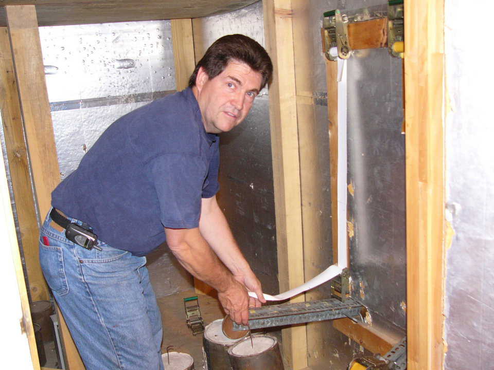 Loading fabric — Don Garrison Superintendent is loading a strip of fabric in the test blocks. Note this is done by actual weights rather than springs.