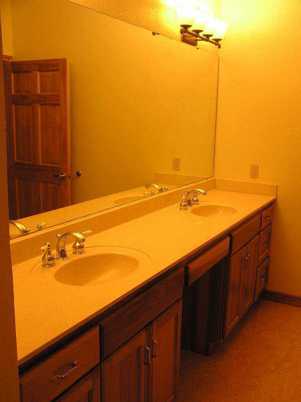 Master bath — A wall of mirrors sits above the double sink and custom cabinets in the master bath.