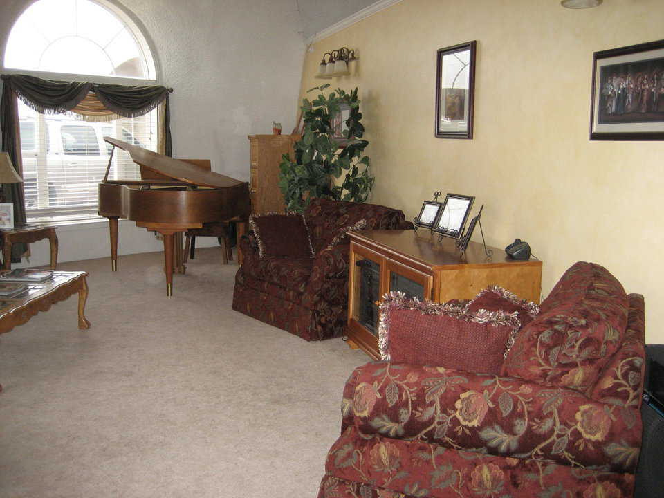 Living room — The home’s spacious living room is just to the left of the entrance. Its curved windows, 6’ wide by 8’ high, echo the shape of the dome.