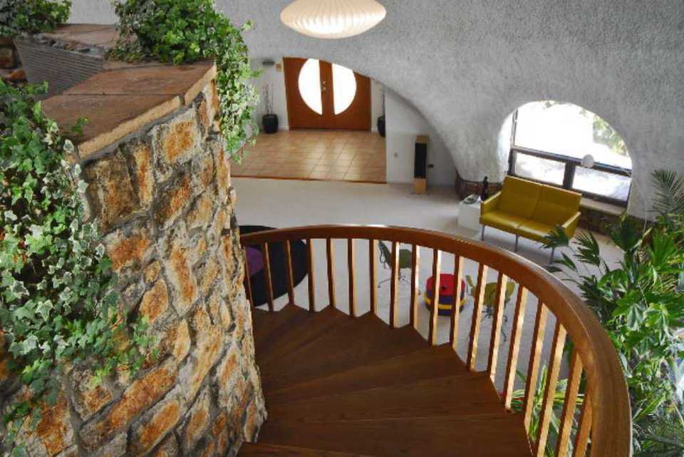 Staircase — A graceful, wood staircase winds about a rock column with waterfalls and leads to 3 bedrooms, and a huge, translucent, custom skylight illuminates the dome’s interior with natural light.