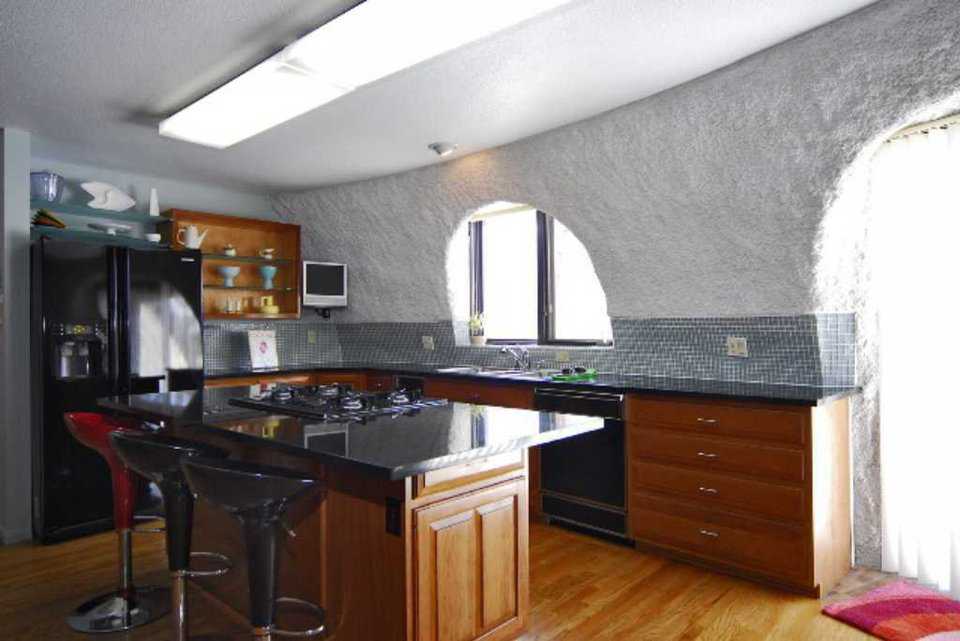 Kitchen — The gourmet kitchen has black slab, granite countertops, custom cabinets, a center island and a planning desk.