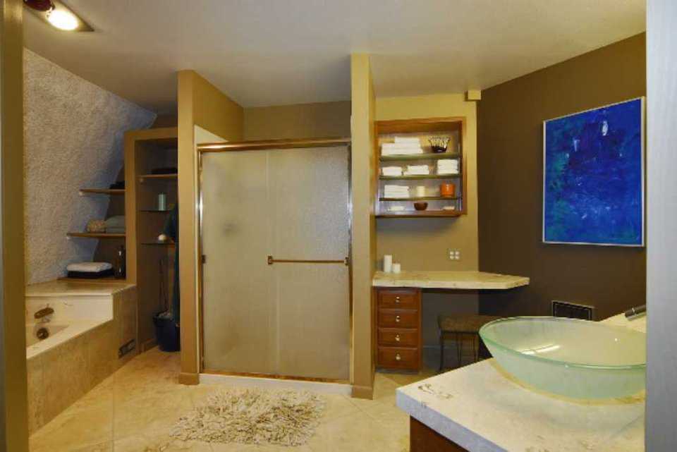 Master Bathroom — The master bath includes travertine countertops, custom cabinets, a private shower and a heated travertine tile floor.