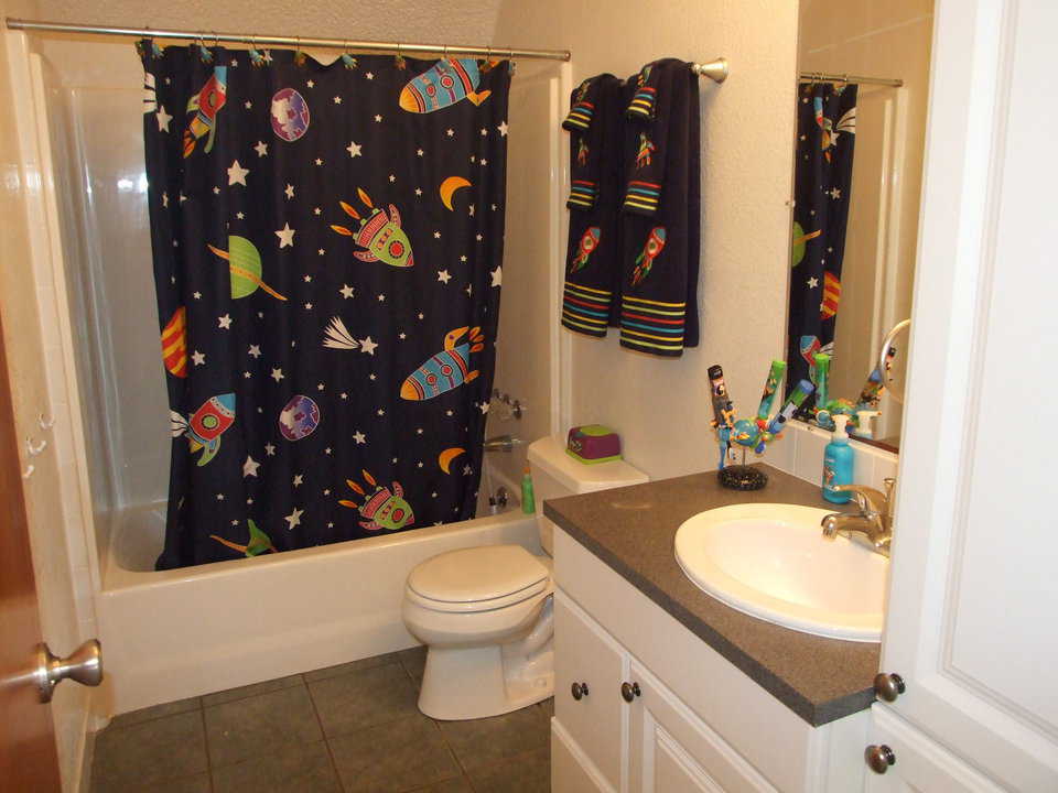 Bathroom — It includes a shower curtain and towels with an outer space design.