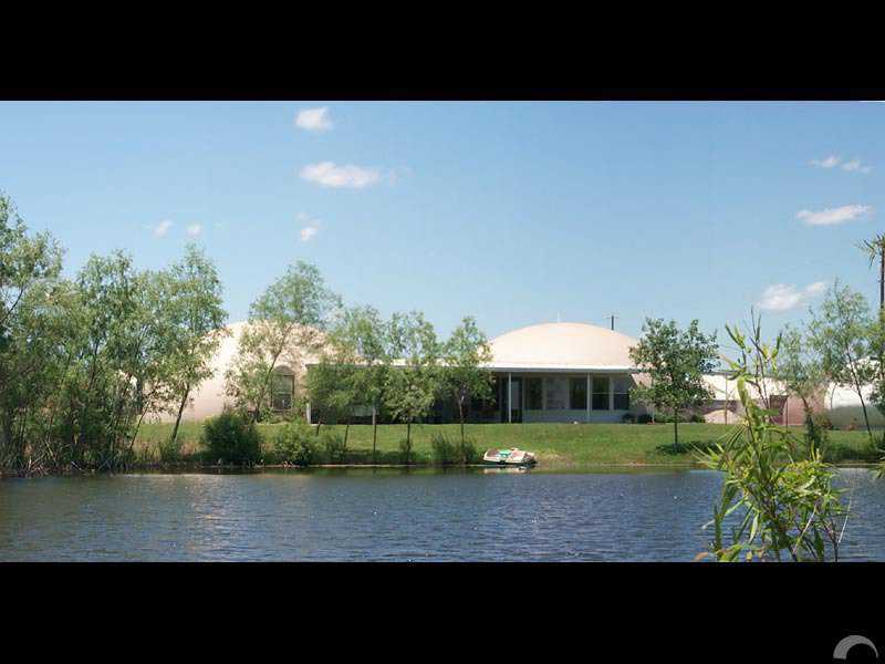 House by the pond — Charca is the Spanish word for pond and Casa means house. This acre pond provides  a spectacular backdrop for its dome-home.