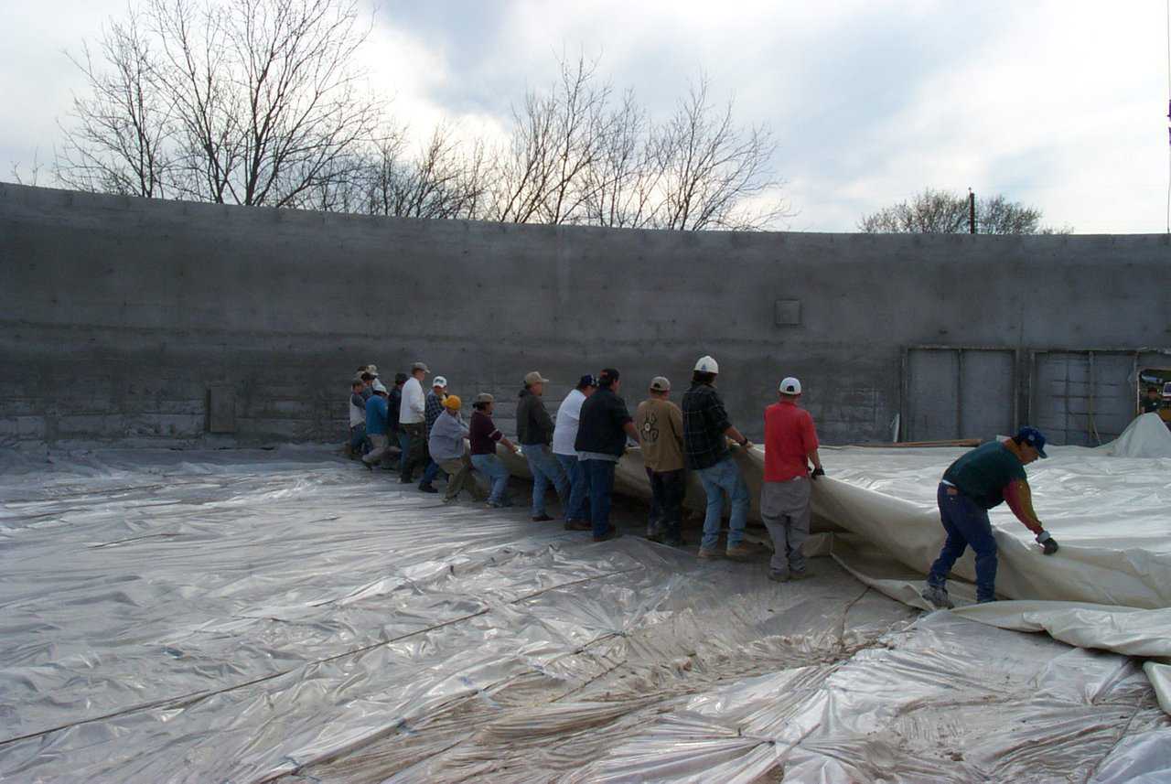 Pulling an Airform — On the inside of a stemwall, a crew pulls out an Airform that will be attached to the top of the stemwall and inflated. Then the Monolithic Dome will be built on the inside.