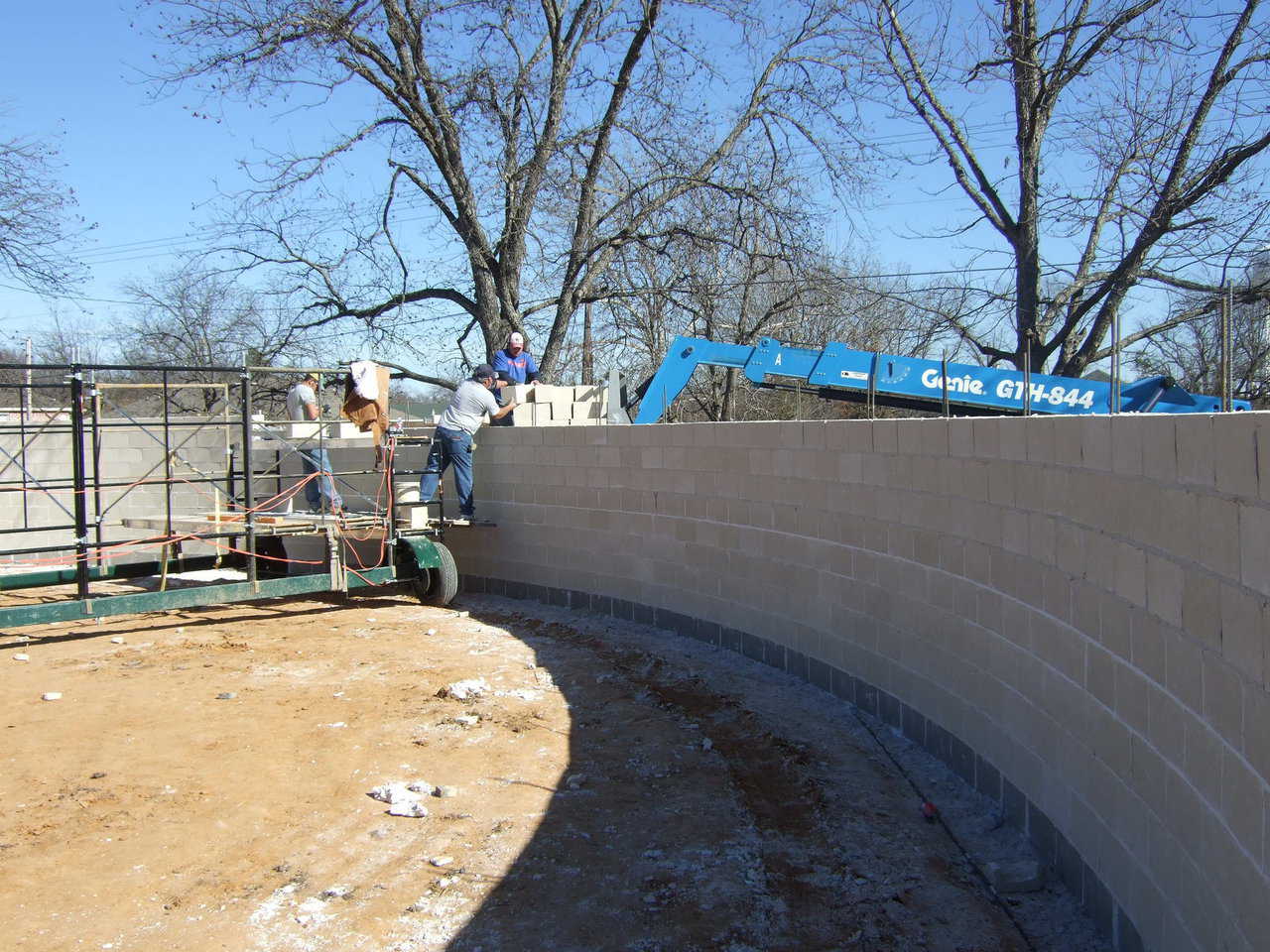 Block Stemwall — Workers create a stemwall using concrete blocks. Although the block wall goes up first, it will only function as a pretty exterior for the Monolithic Dome.