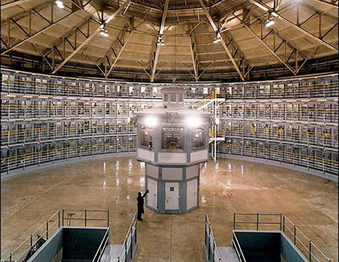 Interior of the Stateville Correctional Center — The Panopticon was intended to be cheaper than the prisons of his time, as it required fewer staff. As the watchmen cannot be seen, they need not be on duty at all times, effectively leaving the watching to the watched.