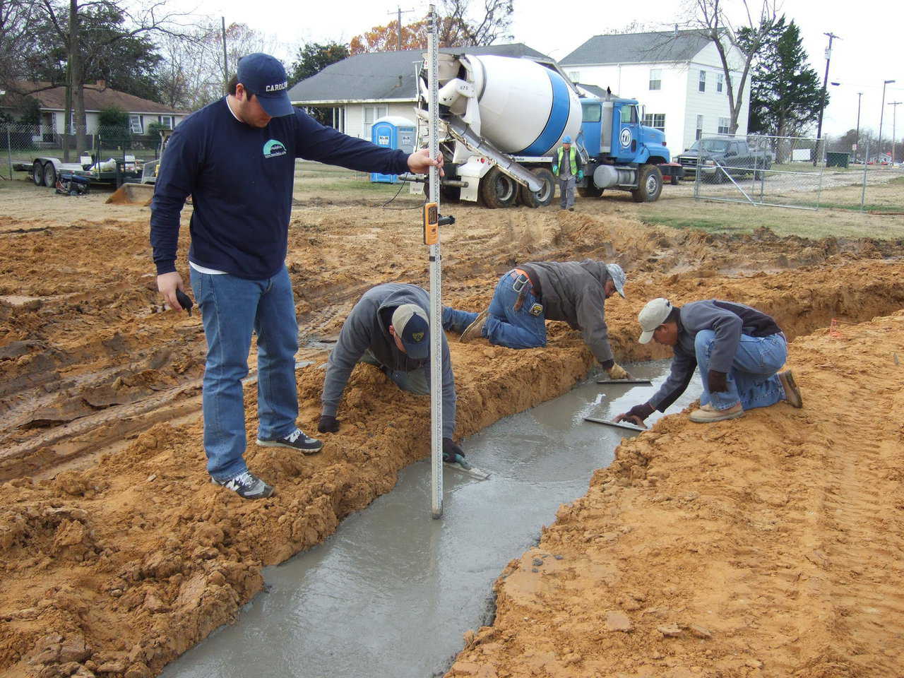 Know-how — Crew Chief, Frank Figueroa, uses a laser level to monitor the concrete levels, as the ring beam is poured and troweled.