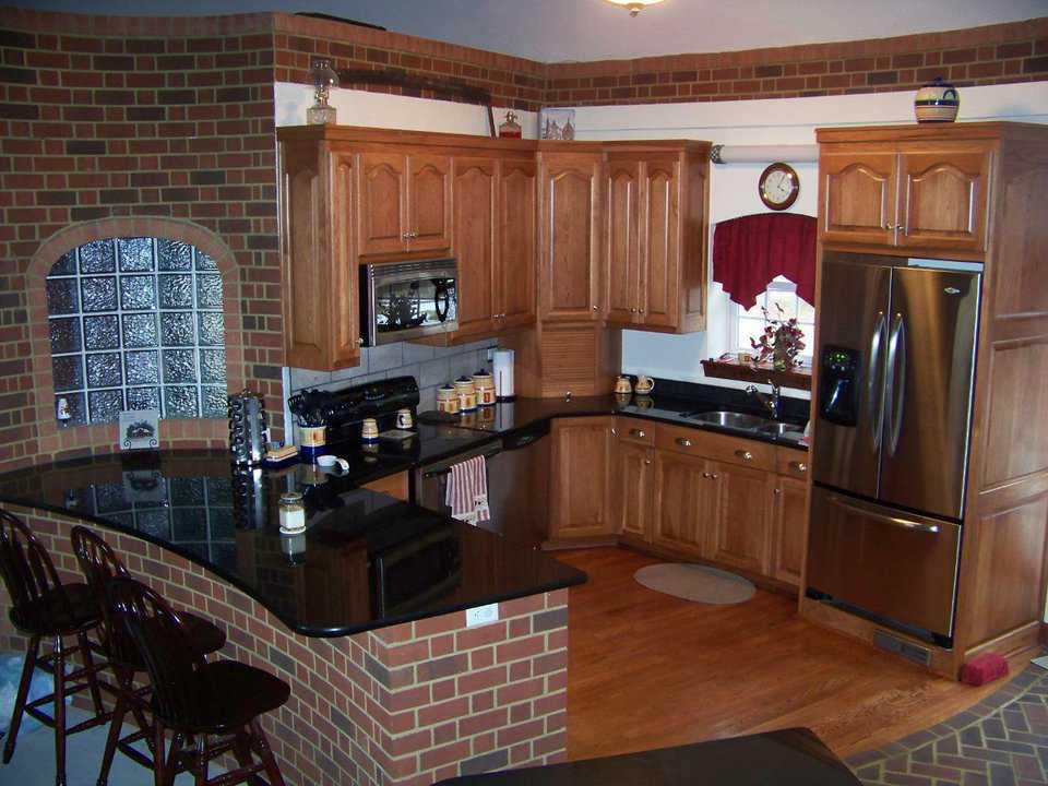 Homey, efficient kitchen — The warm reds and browns in the wood and brick make this an inviting cooking area.