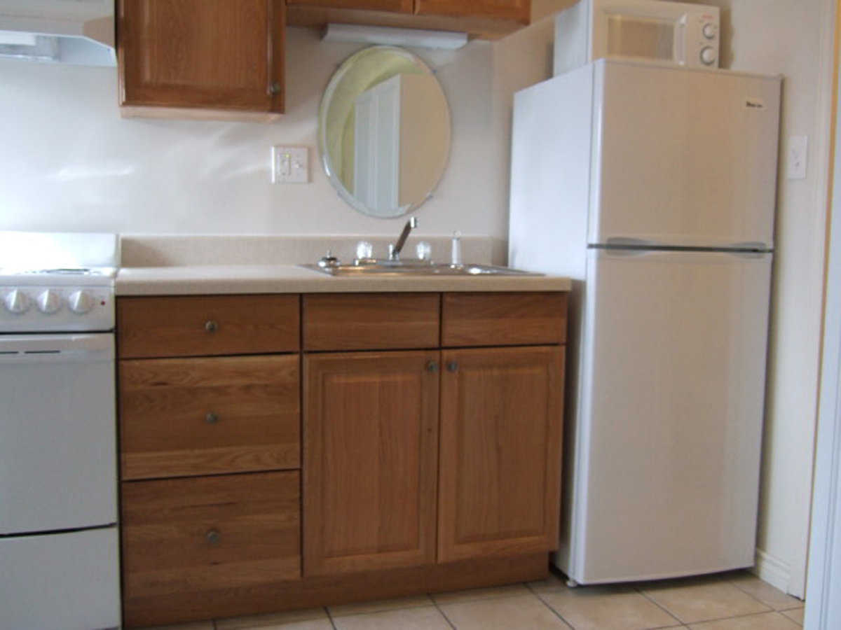 Kitchen — It includes a refrigerator, stove, microwave and cabinets.