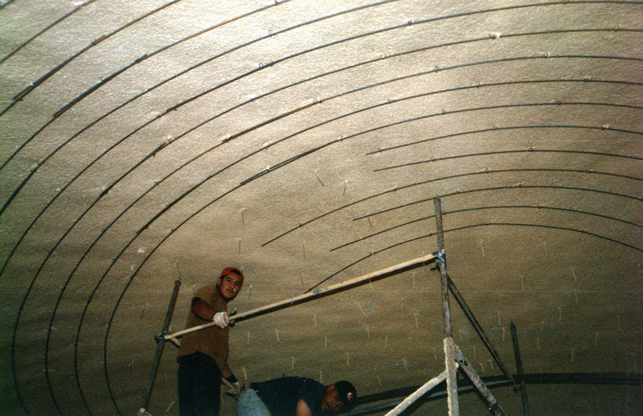 Workers attaching hoop rebar to rebar hangers