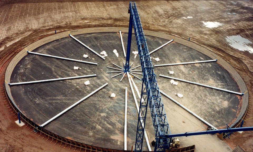 Covered outdoor grain piles — They are usually fenced around the perimeter, with aeration ducts laid in a spoked wheel pattern. Those ducts maintain an even temperature and help keep moisture down inside the grain pile. The grain cover sections, shown above, are ready to be rolled out and fastened together.