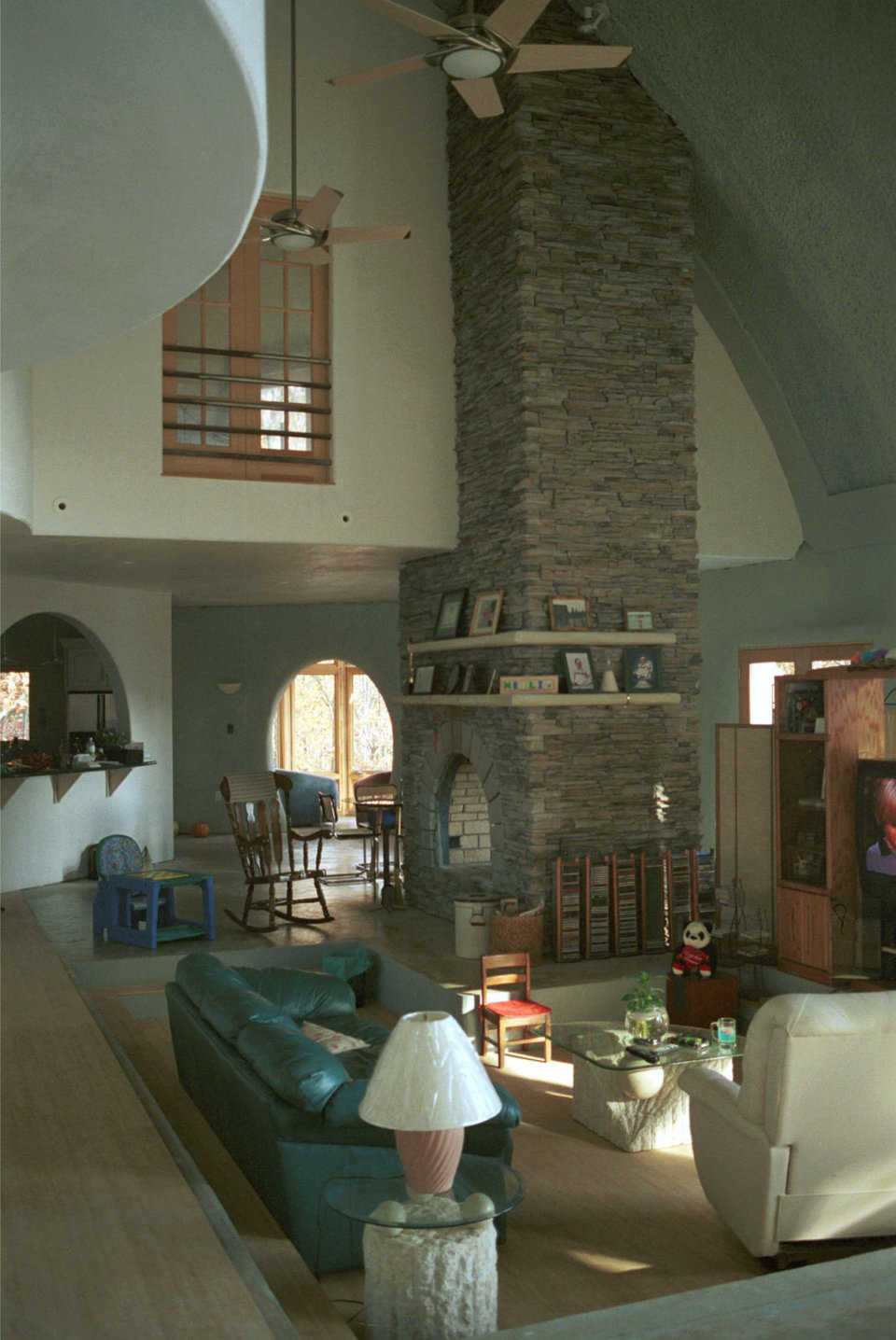 Central living area — Cozy, sunken, central living area features a Cultured Stone fireplace (faux stone). Jim laid about 700 square feet of the stone and never saw two pieces that looked alike — providing an authentic stone appearance. Fireplace is 8′ × 4′ and 25’ tall.