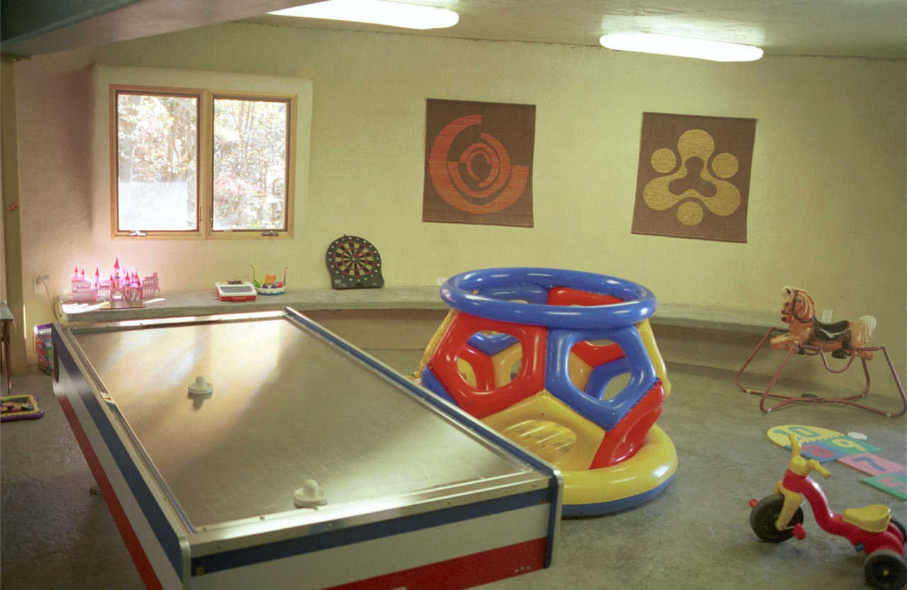 Playroom — The playroom has concrete benches hanging off the dome wall (cantilever). Floor features a polymer overlay, with color and pattern.