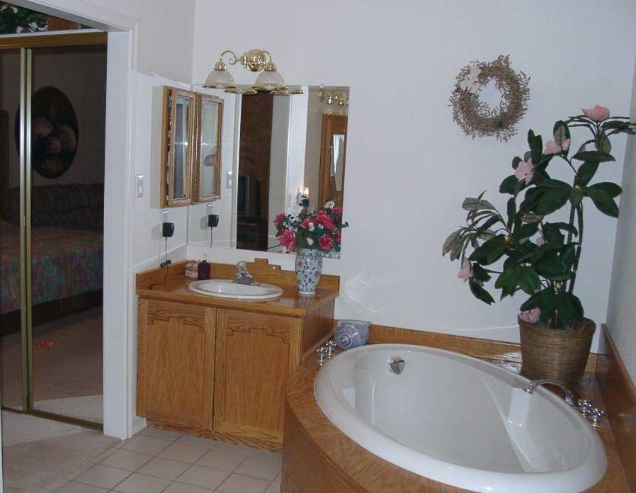 Generous storage — Wood cabinets provide storage in this bathroom.