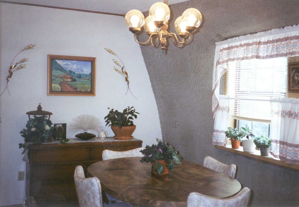 Sunny dining — A curtained window and plants create a delightful eating area.