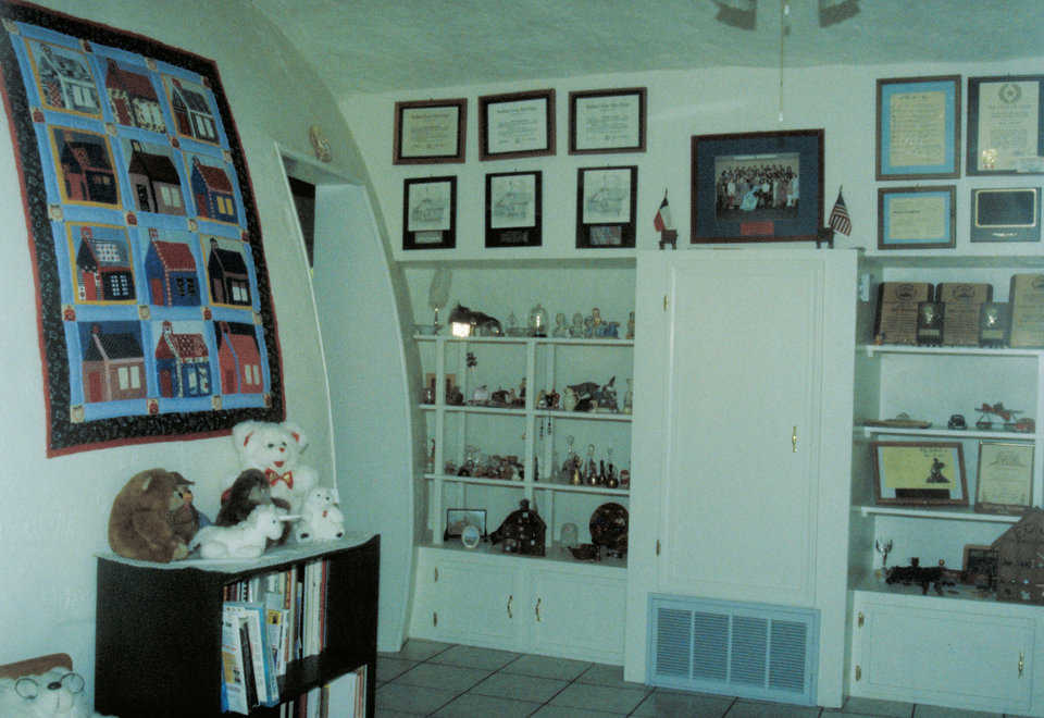 Foyer — Bookshelves and memorabilia line the walls of the conventionally built entryway between the domes. The Hansons researched domes for 15 years before actually deciding on a Monolithic Dome.