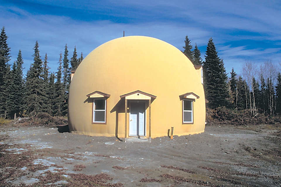 Charles Kneeland Home built by Ray Ansel — Located in Soldotna, Alaska this home is a two-level Monolithic Dome with a diameter of 36 feet on a 9-foot stemwall. Upper level has 2 large bedrooms with walk-in closets. Main floor features a kitchen, living areas and a bedroom. An air-to-air ventilation system keeps air flowing throughout the dome.