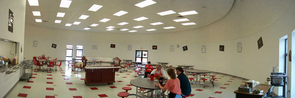Colorful cafeteria — Overhead florescent lighting and large windows give the cafeteria a light, airy atmosphere. Student artwork adorns the walls.
