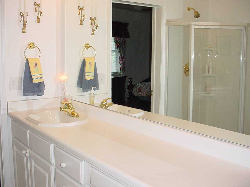 Guest bath — It includes a wall of mirrors and a marble counter top.