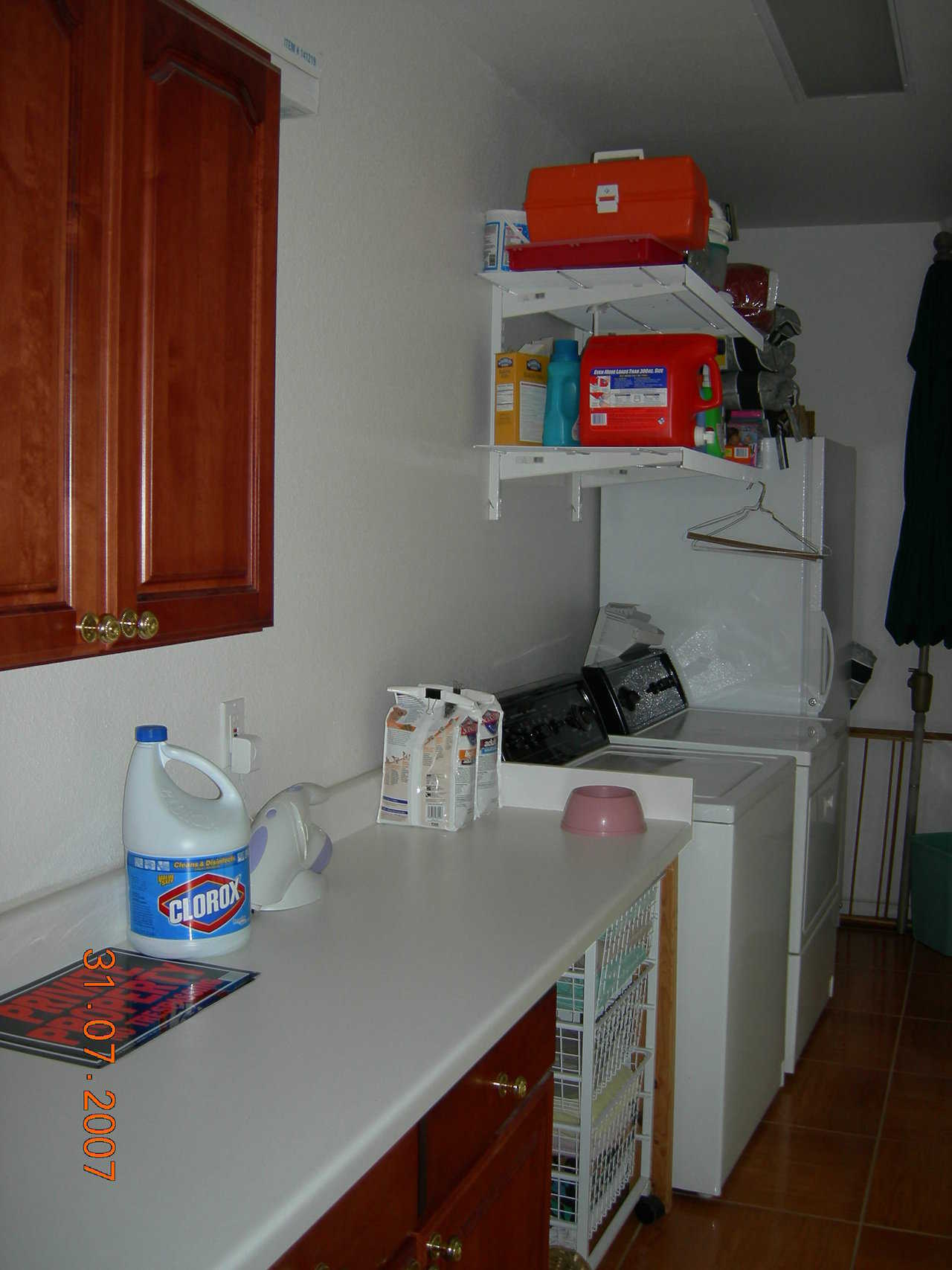 Utility room — Cabinets and hanging shelves provide needed storage.