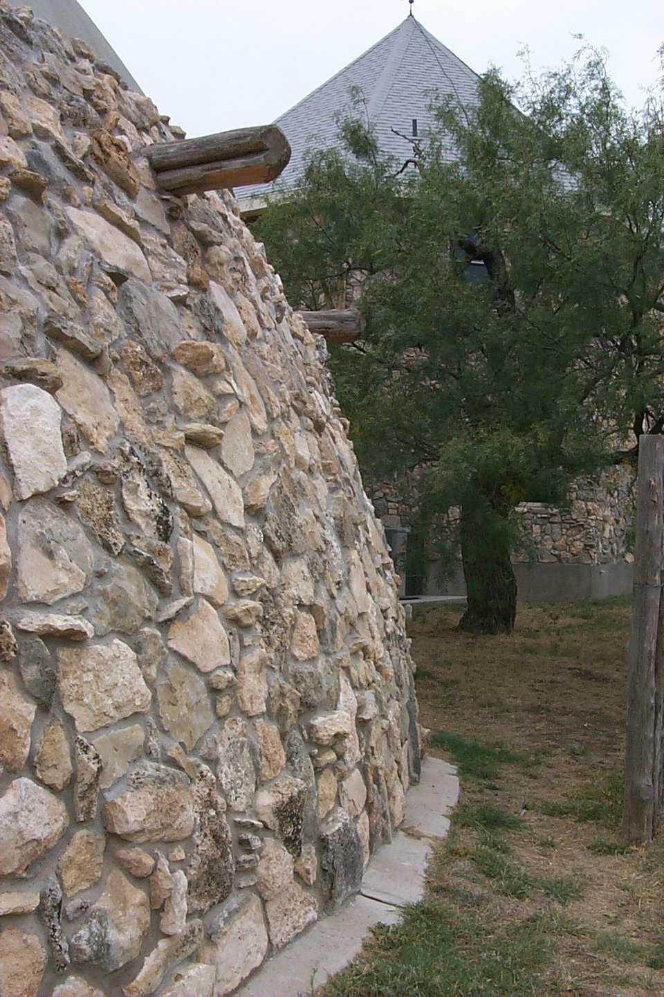 A rock jigwaw puzzle — A craftsman, walking a wheelbarrow over the land, collected the rocks and assembled the wall covering the dome and structural additions.