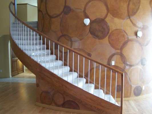 Up and around — A wooden staircase hugs and curves around a wall.