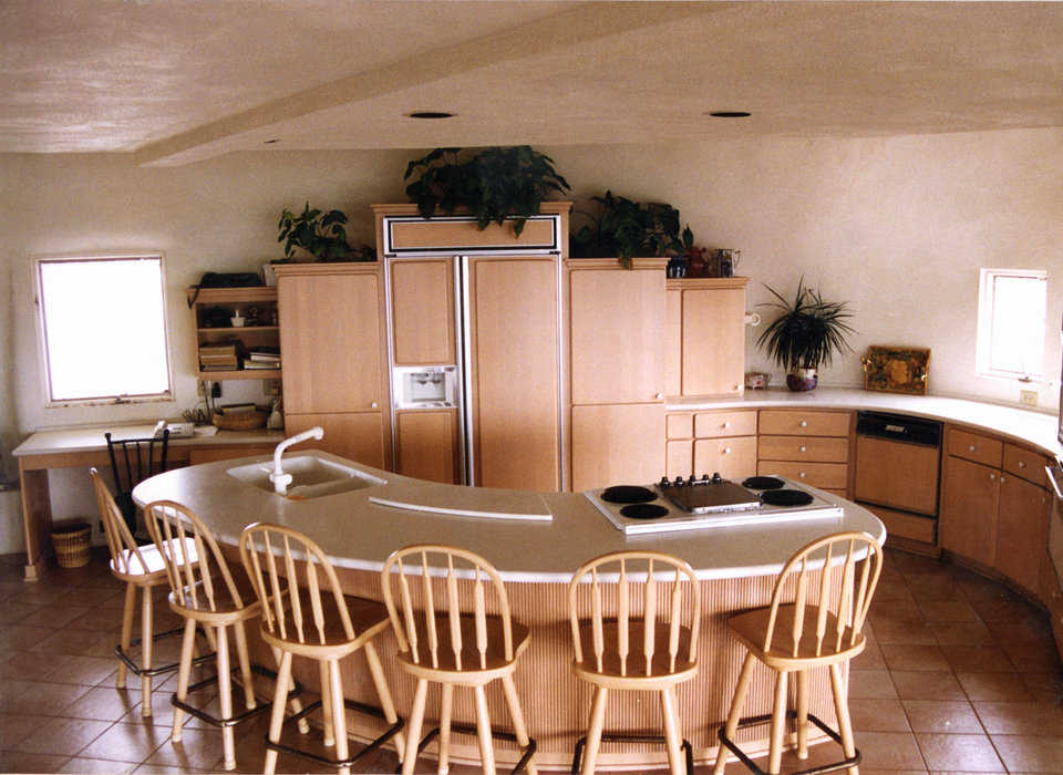Gourmet fixings — Kitchen features an eating island and a work counter, built in opposite curves of Corian. Work counter has sink bowls molded right into it, making it seamless and easy to clean.