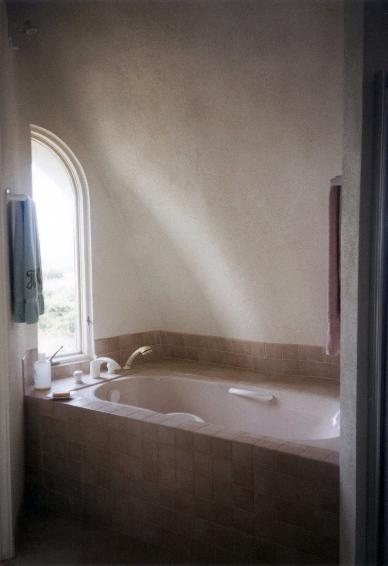 Master bath — It includes a large whirlpool tub with a rounded window just above it.