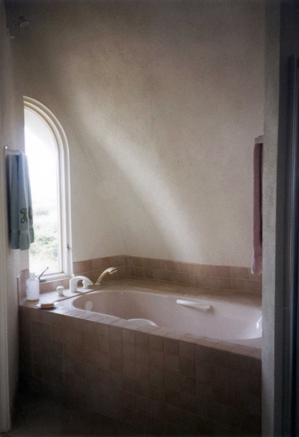 Master bath — It includes a large whirlpool tub with a rounded window just above it.