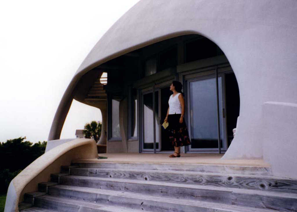 To the beach! — From the balcony, one steps down onto a bermed hill and then down to the beach.