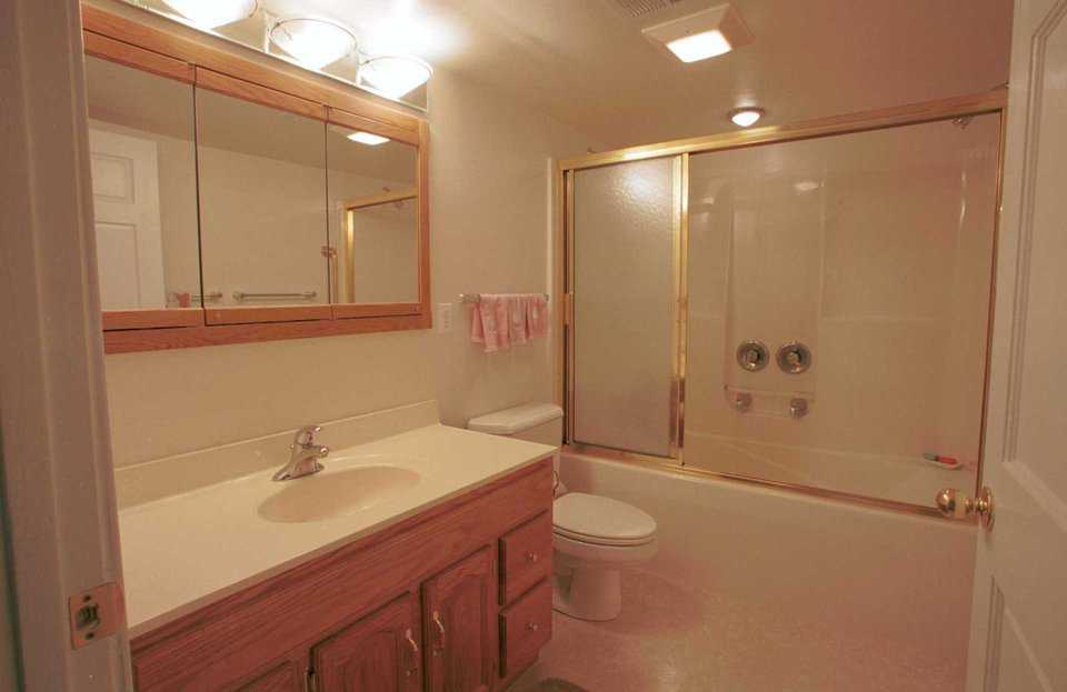 Bathroom — The bathroom is spacious and includes a large shower/tub combination. The faucet is placed on the side of the bath/shower.