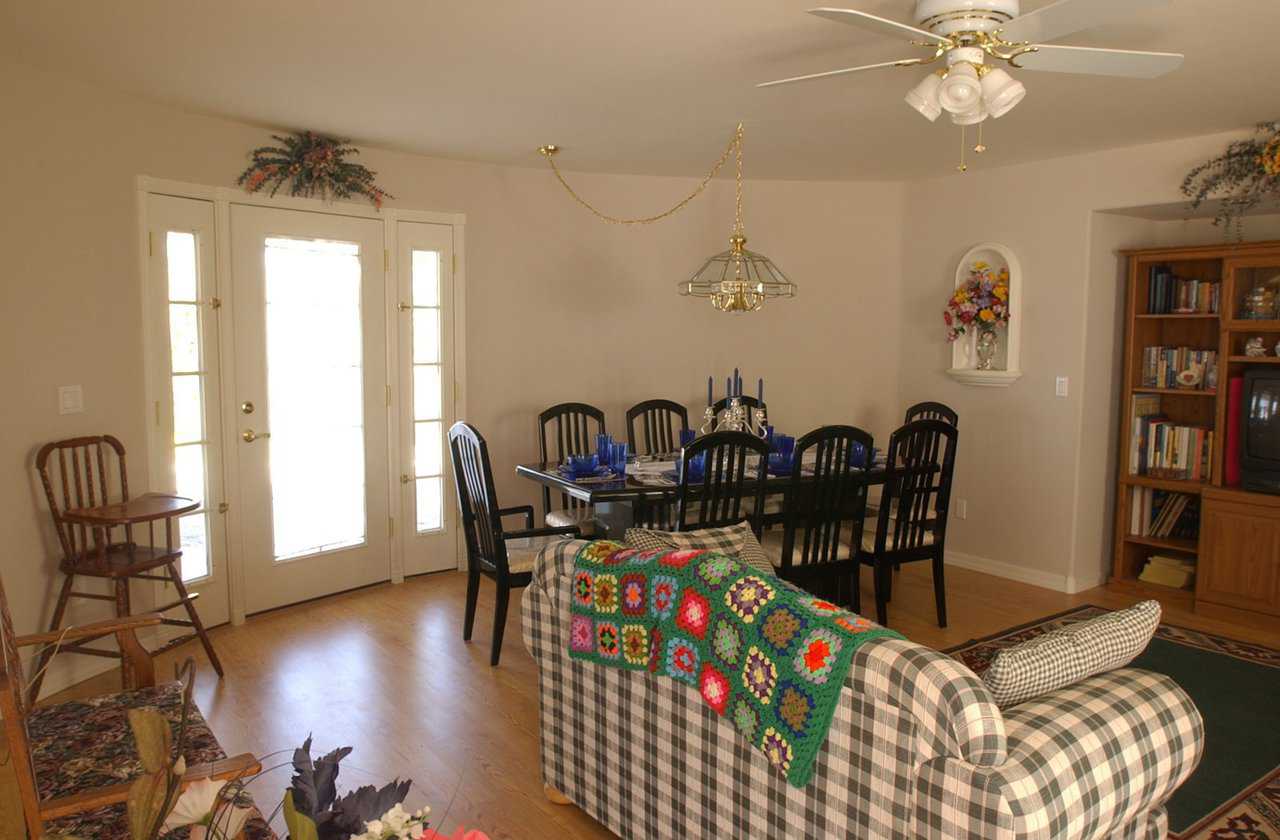 Main living and dining areas — They feature Pergo flooring and a decorative door, with two sidelights, leading to the backyard. An inset entertainment center holds the TV and its companions.