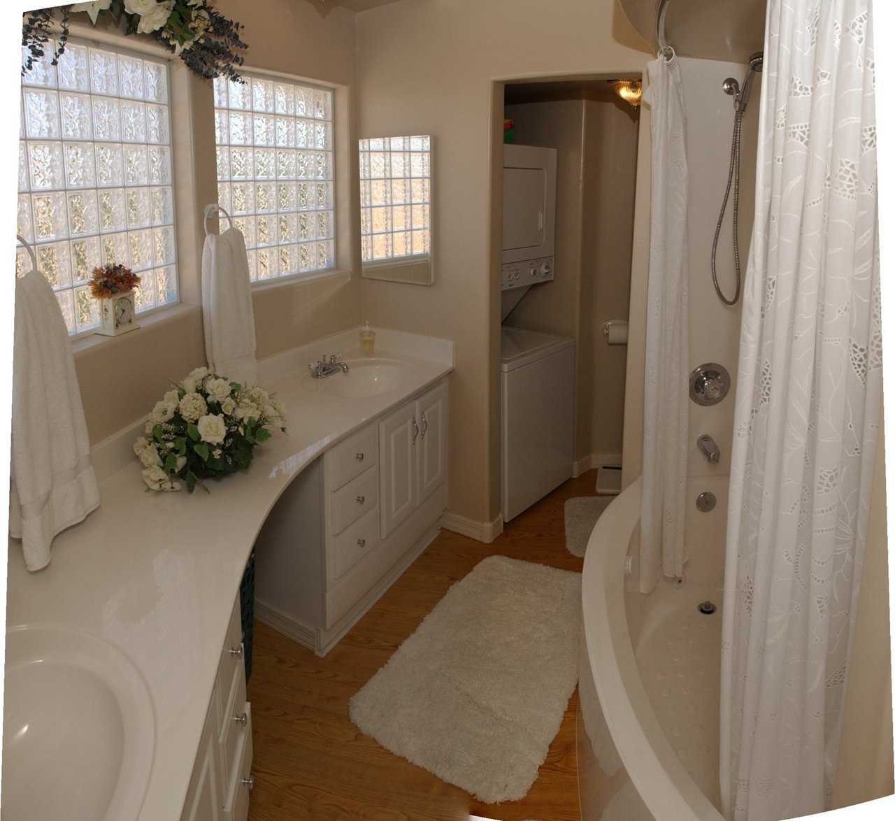 Master bath — Glass block windows allow light to penetrate this sparkling master bathroom. Stackable washer/dryer unit makes laundering convenient. Curved counter tops were custom-made to fit the dome’s curve.