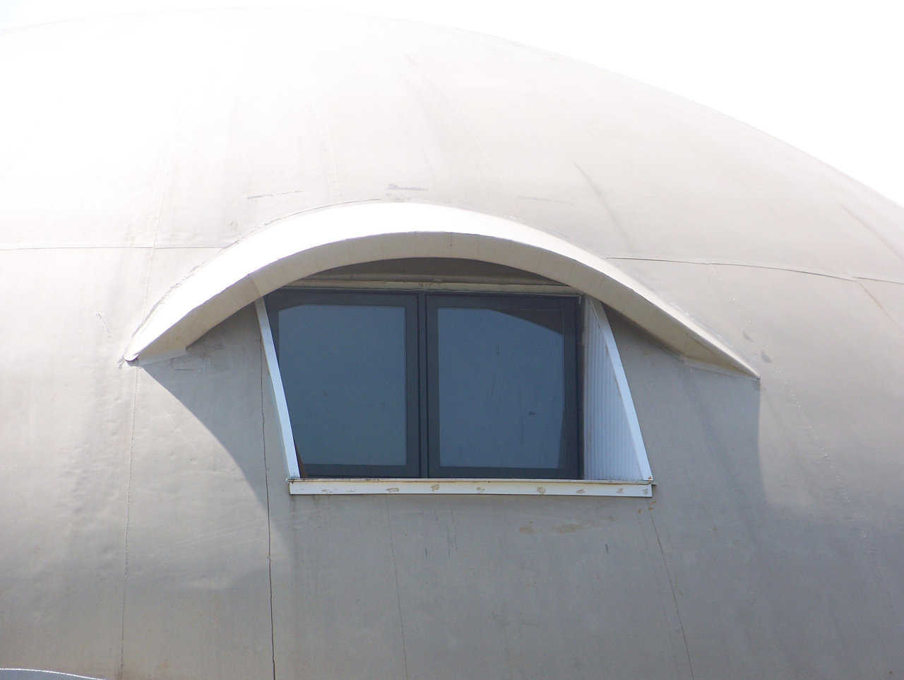 Window with an eyebrow — The eyebrow is a rebar frame epoxied into the concrete shell, sheathed with a plywood and foam sandwich, and topped with more Airform fabric.
