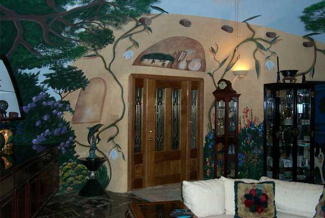 Entryway — It’s graced by decorative vases and curio cabinets that enhance the southwestern motif of this underground Monolithic Dome home.